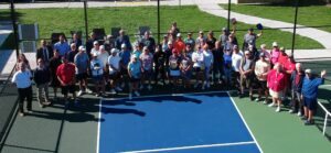 Pickball players and town officials all together on one court looking up to the sky